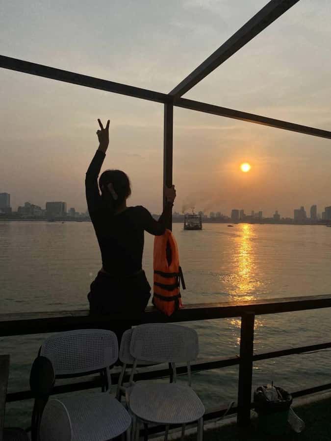 Phnom Penh: Sunset Cruise with Unlimited Beers & BBQ Buffet - The Diamond Island bridge and Cambodian flag